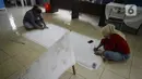 Ibu rumah tangga menyelesaikan pembuatan batik kembang mayang di Kampung Batik, Kelurahan Larangan Selatan, Kota Tangerang, Banten, Rabu (26/8/2020). Di tempat yang menjadi destinasi wisata tersebut kita bisa melihat langsung pembuatan dan mengikuti pelatihan membatik. (merdeka.com/Dwi Narwoko)