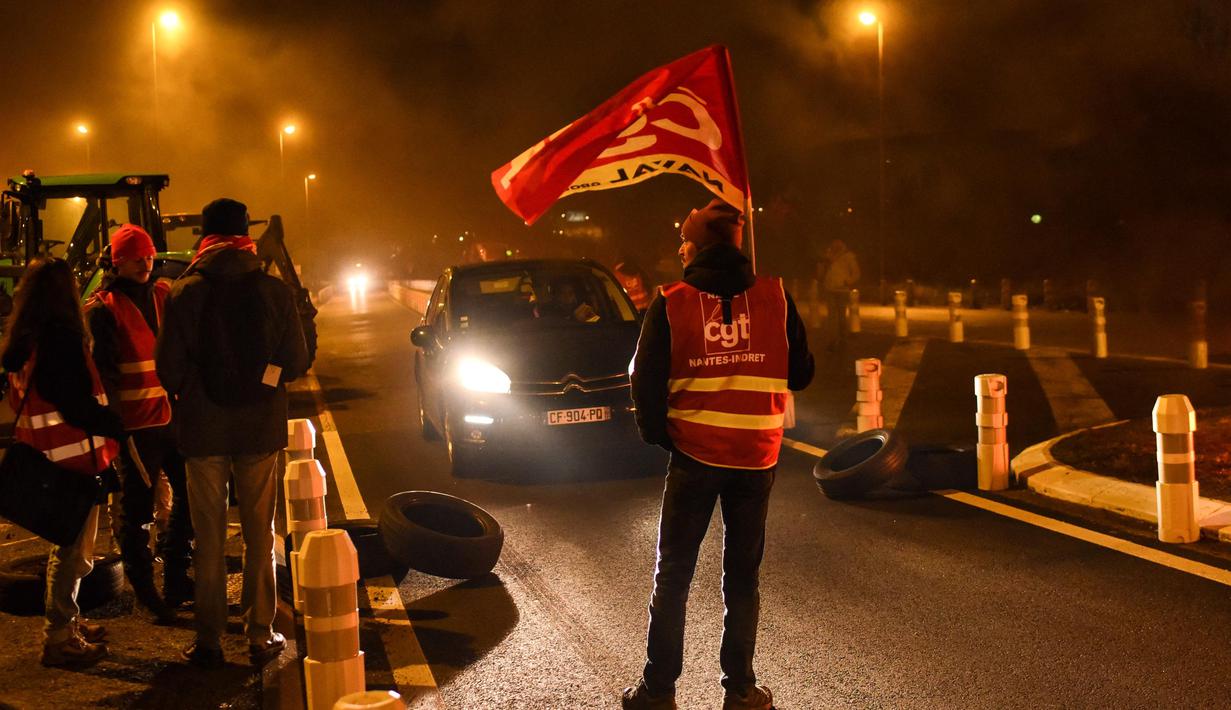 Salah satu anggota serikat pekerja Konfederasi Umum Buruh (CGT) berpartisipasi dalam aksi perlambatan untuk menentang reformasi pensiun, di dekat bandara Nantes di Bouguenais, Prancis barat pada Kamis (16/2/2023). Prancis bersiap-siap menghadapi pemogokan baru dan demonstrasi massal menentang proposal Presiden Prancis untuk mereformasi pensiun Prancis, termasuk menaikkan usia pensiun dari 62 menjadi 64 tahun dan meningkatkan jumlah tahun orang harus memberikan kontribusi untuk mendapatkan pensiun penuh. (Sebastien SALOM-GOMIS/AFP)