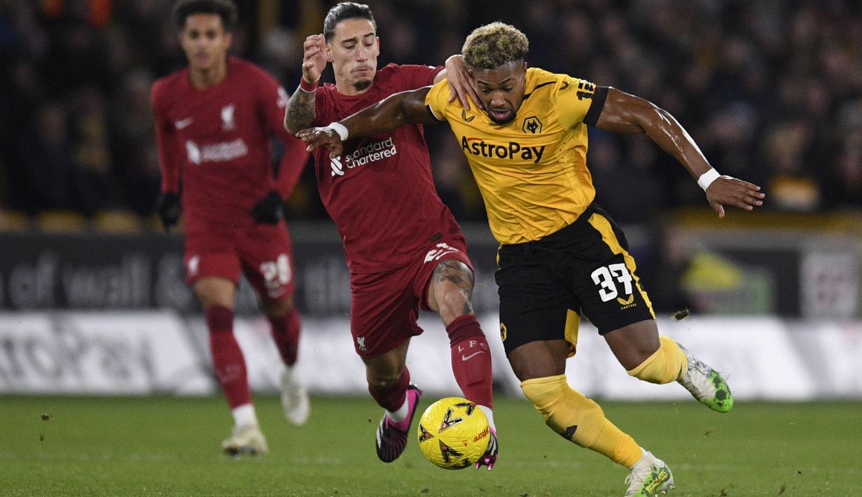 Pemain Wolverhampton Wanderers, Adama Traore berebut bola dengan pemain Liverpool, Kostas Tsimikas pada laga Piala FA 2022/2023 di Molineux Stadium, Wolverhampton, Inggris, 17 Januari 2023. Karier Traore semakin bersinar bersama Wolves. Pemain berkebangsaan Mali tersebut mendarat ke Molineux pada 8 Agustus 2018. Pada musim ini, Traore sempat dipinjamkan ke Barcelona sebelum kembali pada Januari 2023. (AFP/Oli Scarff)
