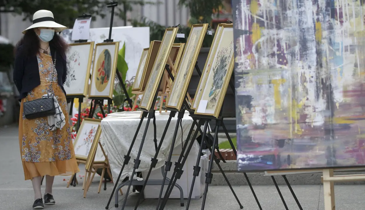 Seorang wanita mengamati karya seni yang dipajang di area terbuka dalam pameran Art Downtown, Vancouver, British Columbia, Kanada, 4 September 2020. Art Downtown merupakan proyek yang memungkinkan seniman dan publik saling terhubung dan menginspirasi serta berbagi kreativitas. (Xinhua/Liang Sen)
