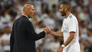 Pelatih Real Madrid, Zinedine Zidane (kiri) bersalaman dengan Karim Benzema merayakan kemenagan atas Barcelona pada Piala Super Spanyol 2017 usai pertandingan melawan Barcelona di stadion Santiago Bernabeu, Spanyol (16/8). (AFP Photo/Gabriel Bouys)