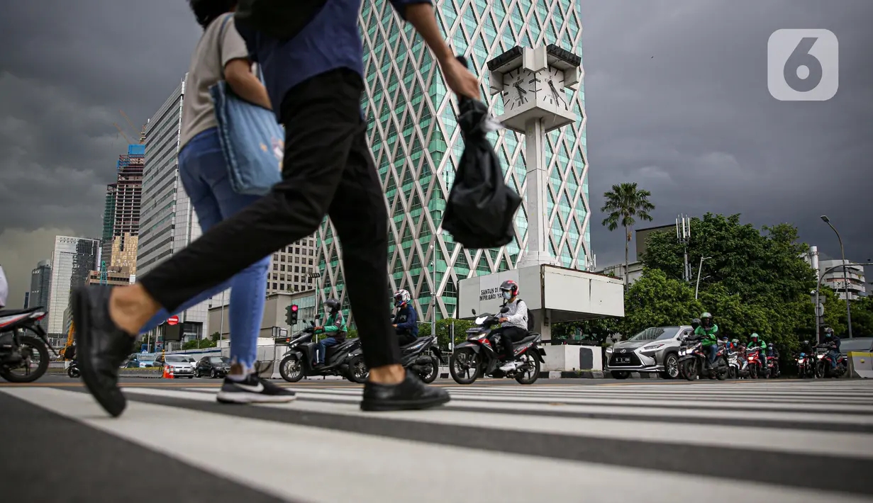 Pejalan kaki melintas di sekitar Menara Jam Thamrin, Jakarta, Sabtu (29/5/2021). PT MRT Jakarta (Perseroda) akan merelokasi Menara Jam Thamrin yang terletak di perempatan antara Jalan MH Thamrin dan Jalan Kebon Sirih pada Juli 2021. (Liputna6.com/Faizal Fanani)