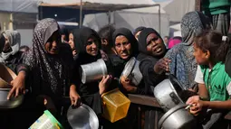 Warga Palestina menunggu bantuan gula dan beras di dapur umum di Khan Younis, Jalur Gaza selatan, Jumat, 31 Oktober 2025. Setiap harinya, ratusan warga, termasuk wanita, anak-anak, dan lansia, terlihat mengantre panjang di dapur umum dan dapur amal yang ada. (AP Photo/Abdel Kareem Hana)
