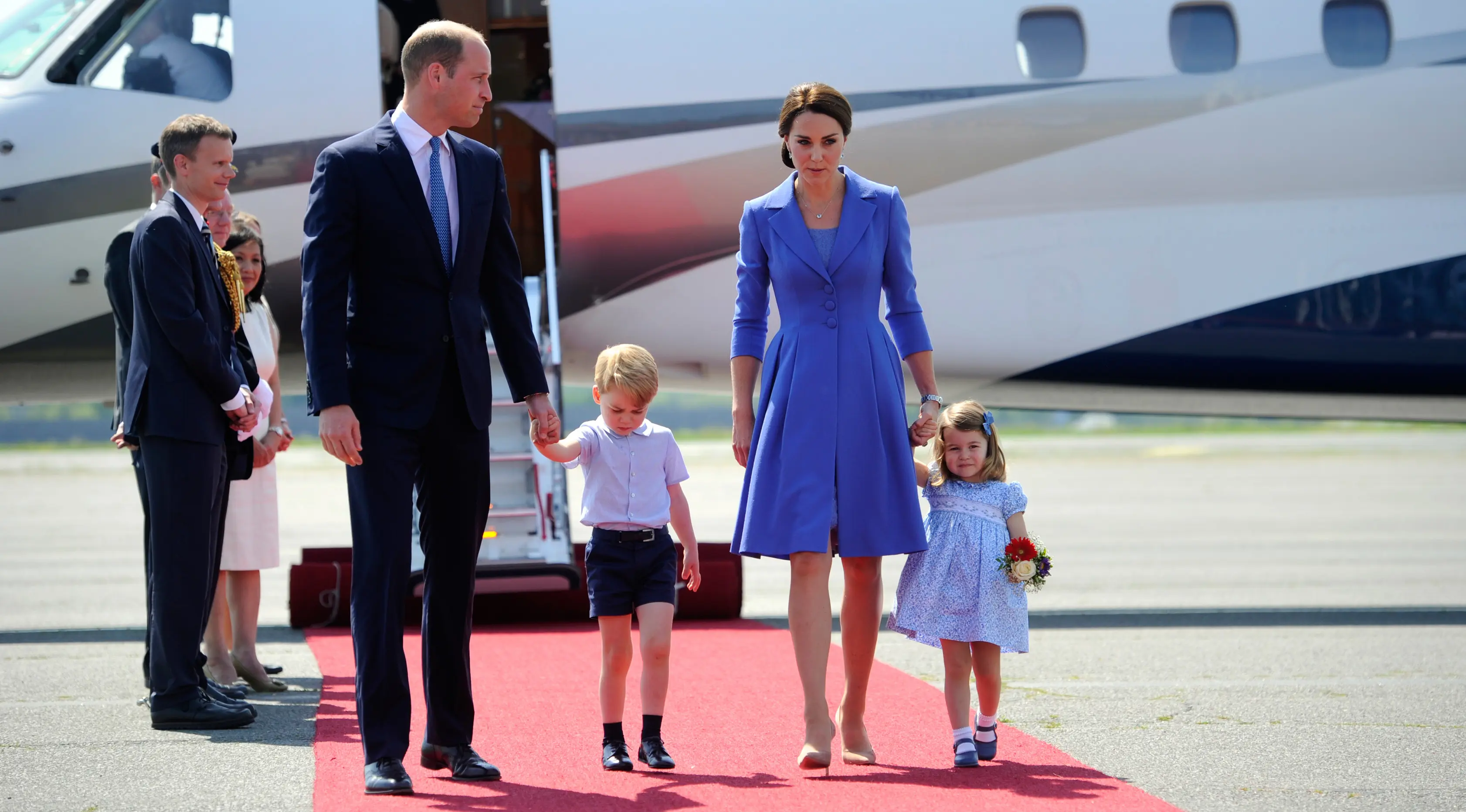 Pangeran William dan Kate Middleton serta kedua anak mereka, Pangeran George dan Putri Charlotte tiba di bandara Tegel, Berlin, Rabu (19/7). Menjalani tur, keluarga kerajaan Inggris itu kompak memakai nuansa biru dalam busananya. (Steffi Loos/Pool via AP)