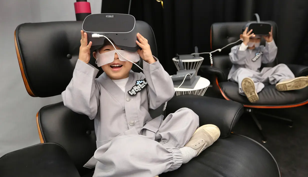 Dua anak lelaki bersiap menggunakan perangkat Virtual Reality (VR) sebelum mencoba layanan 5G di tempat pengalaman LG UPlus 5G di Seoul, Korea Selatan (7/5/ 2019). Perayaan ulang tahun Buddha akan jatuh pada 12 Mei mendatang. (AP Photo/Ahn Young-joon)
