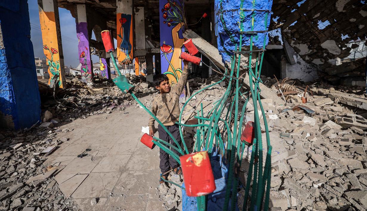Mesir mendorong mandat penjaga perdamaian yang bersifat menjaga perdamaian, bukan memaksa perdamaian, dengan menekankan pentingnya menstabilkan gencatan senjata. Tampak dalam foto, seorang anak laki-laki bermain dengan instalasi seni jalanan dan mural di sisi-sisi bangunan yang hancur di kamp pengungsi Maghazi di luar Deir al-Balah pada Senin 8 Desember 2025. (EYAD BABA/AFP)