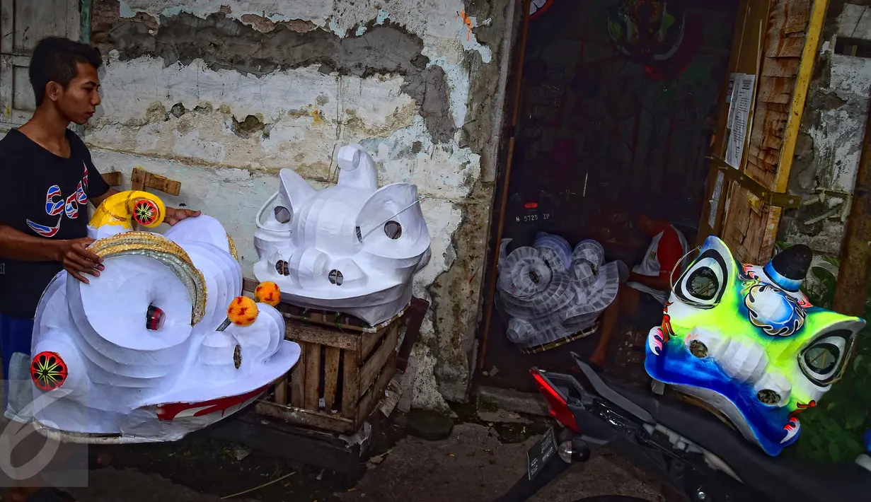 Pekerja membawa kepala barongsai yang akan dicat di tempat pembuatan di Semarang, Jateng, Senin (18/1). Barongsai yang dijual 1 set berkisar 2jt hingga 3,5jt tergantung besar kecilnya ukuran kepala naga. (Foto: Gholib)