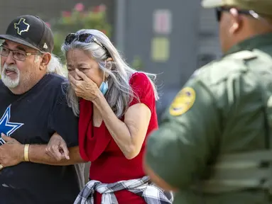 Seorang wanita menangis saat meninggalkan Uvalde Civic Center menyusul penembakan pada hari sebelumnya di Robb Elementary School , Uvalde, Texas, Amerika Serikat, 24 Mei 2022. Sebanyak 14 murid yang dilaporkan tewas dan satu orang korban lain adalah guru. (William Luther/The San Antonio Express-News via AP)