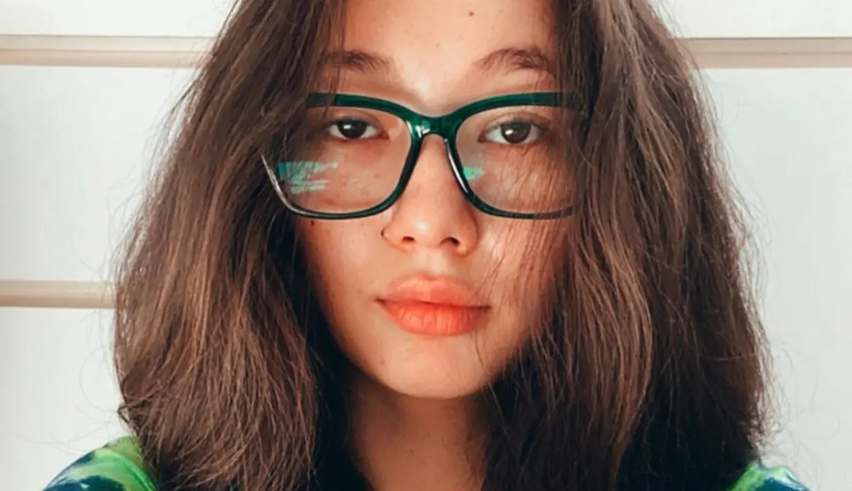 Rambut Devina Aurel terlihat match dengan kaca mata frame hitamnya. Selain rambut panjang, pemilik nama lengkap Devina Aureel Eleazer ini juga dikenal kocak dengan gaya ekspresifnya di media sosial. (Liputan6.com/IG/@devinaaureel)