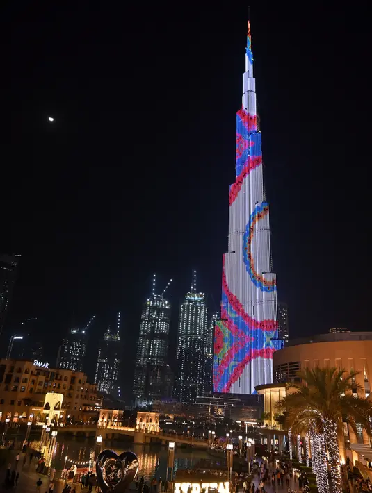 Foto yang diambil pada 4 Januari 2020 memperlihatkan pertunjukan cahaya menyinari Burj Khalifa, bangunan tertinggi dunia, di Dubai. Burj Khalifa yang resmi dibuka pada 4 Januari 2010 itu merayakan hari jadinya yang ke-10 dengan pertunjukan lampu LED khusus. (Giuseppe CACACE / AFP)