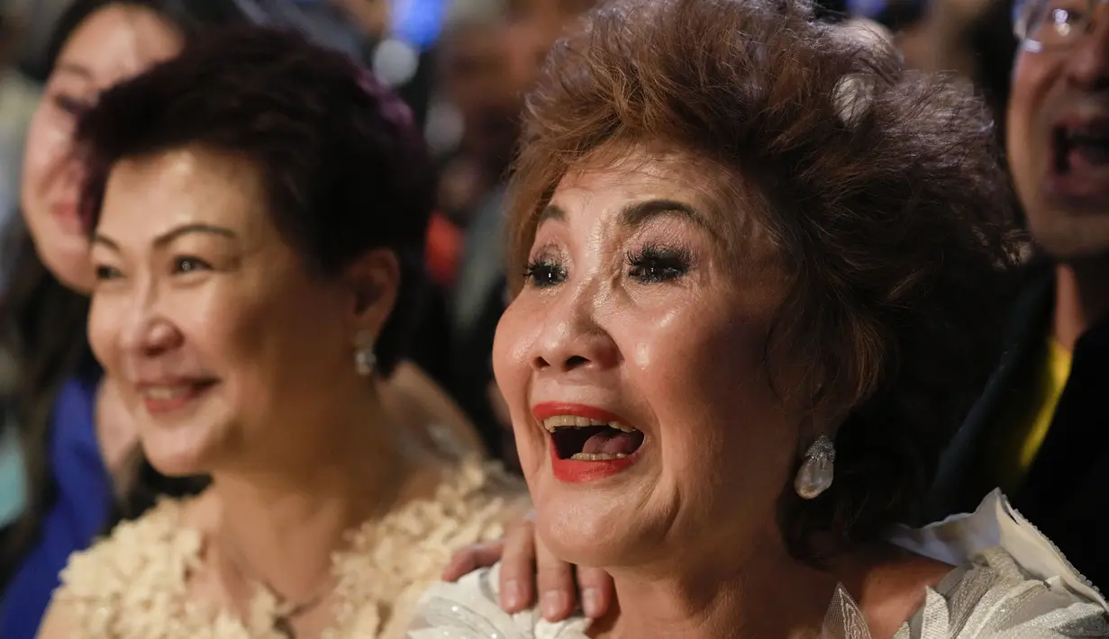 Janet Yeoh (kanan), ibu dari Michelle Yeoh, merayakan setelah putrinya menang untuk kategori aktris terbaik (Actress in Leading Role) selama Academy Awards ke-95 di Los Angeles, seperti yang terlihat dalam acara tayangan langsung di sebuah bioskop di Kuala Lumpur, Malaysia, Senin (13/3/2023). Michelle Yeoh menang berkat film Everything Everywhere All At Once yang sensasional. (AP Photo/Vincent Thian)