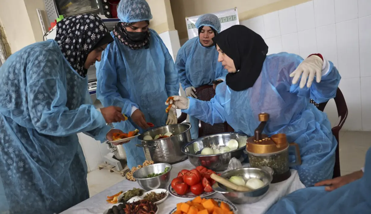 Para wanita membuat maftoul atau couscous di Khan Yunis, Jalur Gaza, Palestina, 10 Januari 2022. Maftoul dibuat dengan merebus gandum, lalu dijemur dan dipecahkan, kemudian digulung dengan tangan dan tepung terigu organik yang baru digiling, selanjutnya dikukus dan dijemur. (SAID KHATIB/AFP)