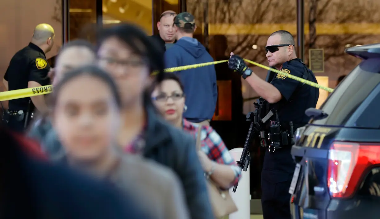 Polisi San Antonio mengevakuasi pengunjung setelah terjadinya baku tembak di Rolling Oaks Mall, Texas, Minggu (22/1). Baku tembak terjadi setelah aksi perampokan di sebuah toko perhiasan Kay Jewelers di mal itu digagalkan pengunjung. (AP Photo/Eric Gay)