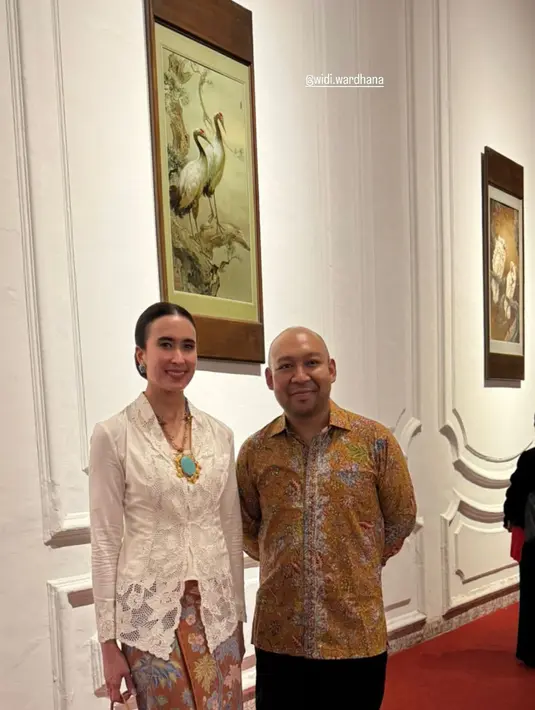 Menpar Widi Wardhana kenakan kebaya encim putih berpadu dengan kain Batik cokelat bermotif pastel. Ia terlihat jinjing tas etnik dari anyaman [@widi.wardhana]