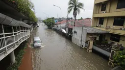 Hujan yang mengguyur sejak pagi tadi menyebabkan genangan di beberapa ruas jalan Ibukota Jakarta, Sabtu (27/12/2014). (Liputan6.com/Miftahul Hayat)