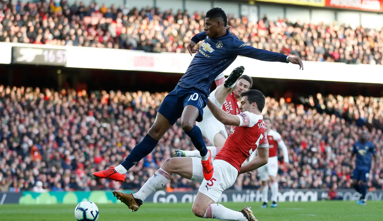 Marcus Rashford dihentikan Sokratis Papasthatopoulus pada laga lanjutan Premier League yang berlangsung di Stadion Emirates, London, Minggu (10/3). Arsenal menang 2-0 atas Man United. (AFP/Ben Stansall)