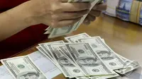 Pegawai Bank sedang menghitung dengan seksama mata uang dollar yang akan ditukarkan dengan rupiah, Jakarta, Kamis (23/10/2014) (Liputan6.com/Johan Tallo) 