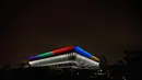 Gambar menunjukkan Tokyo Aquatics Center, tempat acara renang, menyelam, dan renang artistik, tampak disoroti warna-warni cahaya Olimpiade untuk menandai 100 hari jelang pembukaan Olimpiade Tokyo 2020 di Tokyo, Jepang, pada 14 April 2021. (Behrouz MEHRI / AFP)