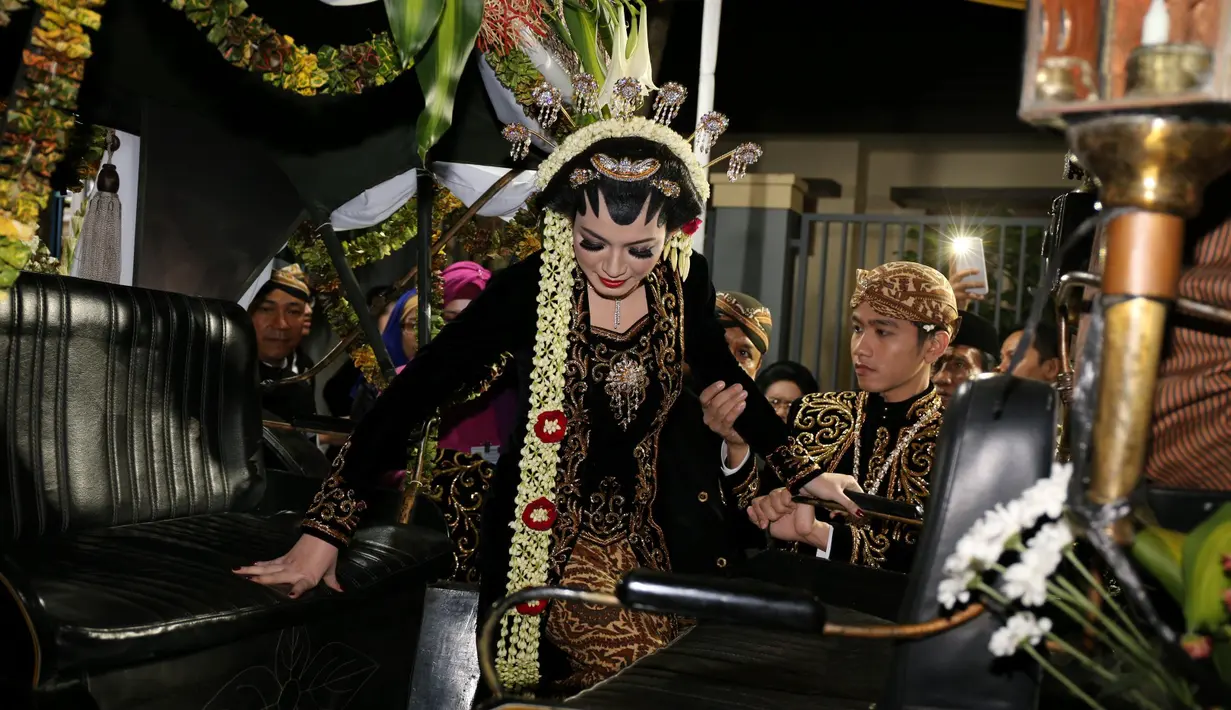 Gibran membantu istrinya Selvi Ananda turun dari kereta kencana. (Galih W. Satria/bintang.com)