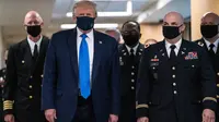 Presiden Amerika Serikat Donald Trump mengenakan masker saat mengunjungi Pusat Kesehatan Militer Nasional Walter Reed di Bethesda, Maryland, Sabtu (11/7/2020). Donald Trump akhirnya menggunakan masker untuk pertama kalinya di depan umum sejak pandemi COVID-19 melanda negara itu.  (ALEX EDELMAN/AFP)