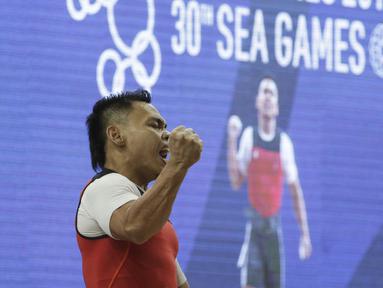 Lifter Eko Yuli usai melakukan angkatan saat SEA Games 2019 cabang angkat besi nomor 61 kg di Stadion Rizal Memorial, Manila, Minggu (1/12). Dirinya meraih emas dengan total angkatan 309 kg. (Bola.com/M Iqbal Ichsan)