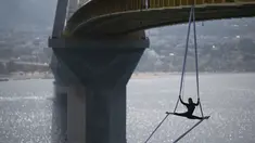 Seorang koreografer dan penari "ekstrem", Katerina Soldatou melakukan tarian di bawah jembatan Rio-Antirio, Yunani selatan, Senin (12/3).  Jembatan ini merupakan jembatan bentang kabel terpanjang di dunia. (AP Photo/Petros Giannakouris)