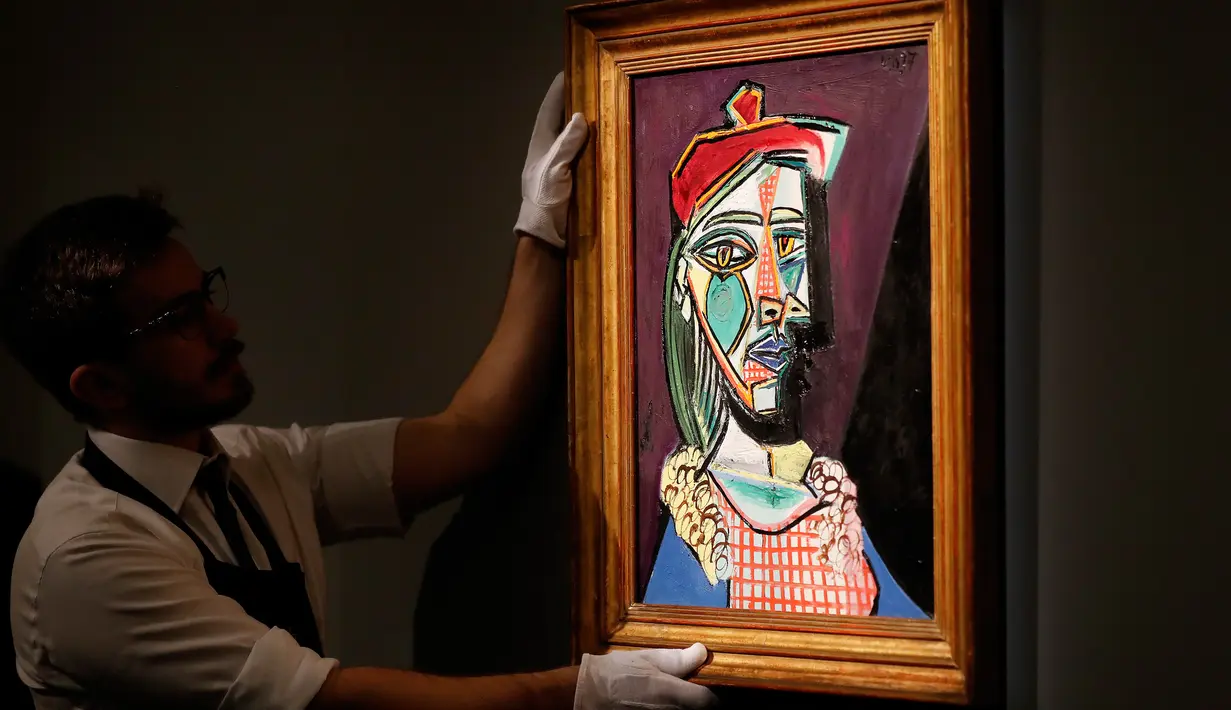 Petugas rumah lelang Sotheby menata lukisan Pablo Picasso bertema Marie-Therese Walter pada sesi pemotretan di London, Rabu (22/2). Lukisan Walter itu dibuat beberapa bulan setelah Picasso menyelesaikan karya besarnya, Guernica (1937). (AP/Frank Augstein)