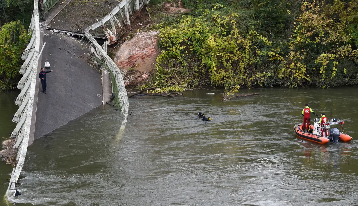 Tim penyelamat menyelam di  sungai Tarm, dekat jembatan gantung yang ambruk di Prancis, Selasa (18/11/2019). Sebanyak 60 petugas penyelamatan, 40 anggota kepolisian, 67 petugas pemadam kebakaran, dan beberapa penyelam dikerahkan untuk melakukan pencarian di dalam sungai Tarn. (ERIC CABANIS/AFP)