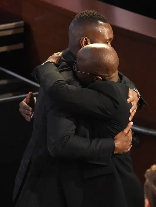 Aktor Mahershala Ali mendapat pelukan sebelum naik podium untuk menerima Piala Oscar pertamanya pada Academy Awards ke-89, Los Angeles, Minggu (26/2). Ali berjaya di kategori Best Supporting Actor lewat film Moonlight (Photo by Chris Pizzello/Invision/AP)