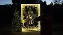 Satu keluarga berpose untuk foto pada pertunjukan cahaya Holiday Road di Calabasas, California, Amerika Serikat, 10 Desember 2021. Holiday Road digelar sepenuhnya setelah pandemi COVID-19 mengubah festival cahaya tahunan ini menjadi acara drive-thru tahun lalu. (AP Photo/Jae C.Hong)