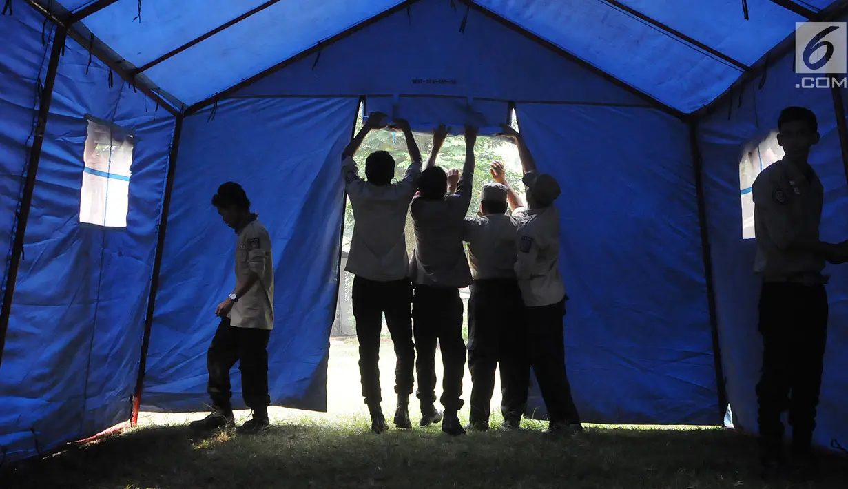 Anggota Tagana Kota Tangerang Selatan mendirikan Shelter (pengungsian) di Situ Gintung, Ciputat, Kamis (12/7). Pelatihan tersebut dilakukan untuk penyelamatan, memberikan rasa aman dan pelayanan bagi korban bencana alam. (Merdeka.com/Arie Basuki)