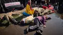 Krisis kemanusiaan tak terelakkan. Tampak dalam foto, orang-orang berpartisipasi dalam pertunjukan seni yang menggambarkan serangan Rusia saat anggota komunitas Ukraina menggelar protes untuk menandai tahun keempat sejak dimulainya invasi skala penuh Rusia ke Ukraina di Bukares, Rumania, Minggu 22 Februari 2026. (AP Photo/Vadim Ghirda)