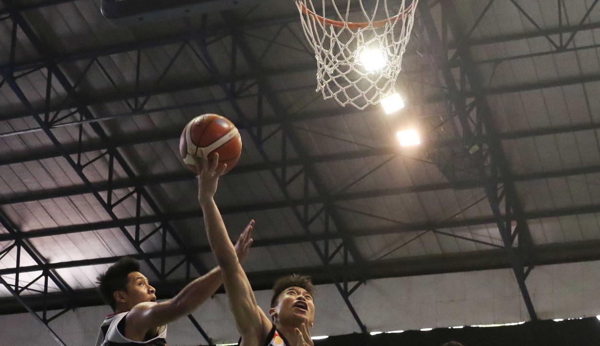 Pemain M88 Aspac Jakarta, Rizky Effendi (kiri) menghalau tembakan pemain NSH Jakarta, Yoseph Wiajay pada laga IBL Reguler Season di Hall A Senayan, Jakarta, Minggu (10/1/2016). Aspac Jakarta menang 78-61. (Bola.com/Nicklas Hanoatubun)