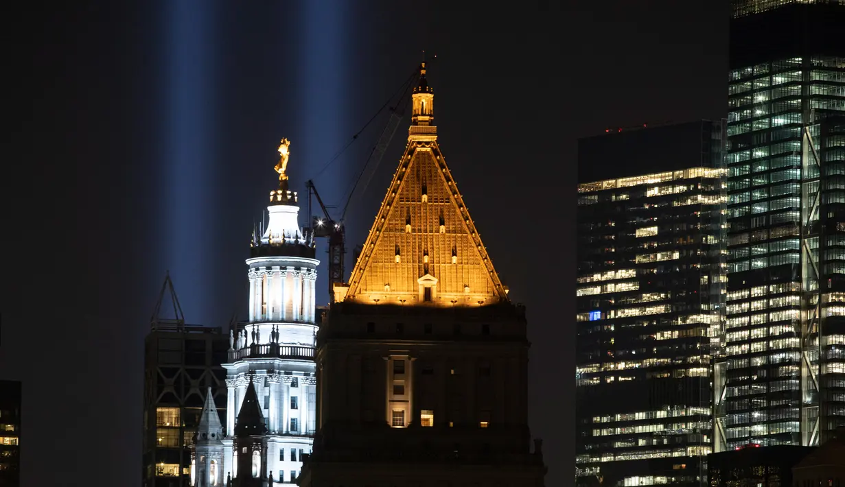 Instalasi cahaya bertajuk 'Tribute in Light' memperingati serangan gedung kembar menerangi langit di lower Manhattan, New York, Selasa (10/9/2019). Cahaya kembar itu jadi simbol menara kembar WTC yang hancur diserang kelompok pembajak pesawat 18 tahun silam. (AP/Mark Lennihan)