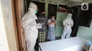 Tim relawan dari Polmas Bogor berdoa di depan peti jenazah warga korban COVID-19 yang meninggal saat isolasi mandiri di Bogor, Jawa Barat, Jumat (9/7/2021). Relawan menyediakan peti jenazah, memandikan, membungkus hingga membawanya ke tempat pemakaman khusus COVID-19. (merdeka.com/Arie Basuki)