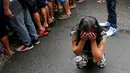 Salah satu anggota keluarga menangis saat melihat tubuh Nora Acielo tewas ditembak orang tak dikenal di Manila, Filipina, Kamis (8/12). Acielo ditembak saat sedang mengantarkan kedua anaknya berangkat sekolah. (REUTERS/Erik De Castro)