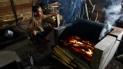 Seorang pria memanggang biji kopi robusta menggunakan alat tradisional di salah satu industri rumah tangga di Ulee Kareng, Aceh, Rabu (20/11/2019). Kopi yang diolah secara tradisional itu dijual dengan kisaran harga beragam tergantung kualitas. (CHAIDEER MAHYUDDIN/AFP)