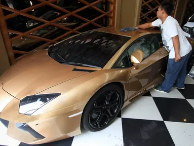 Petugas membersihkan mobil Lamborghini Aventador LP 700-4 tahun 2013 di Auto One Cars Boutique, Jakarta, Senin (5/10/2015). Mobil sport mewah tersebut akan dilelang DJKN Kemenkeu dengan nilai limit Rp 8,26 miliar. (Liputan6.com/Immanuel Antonius)