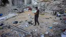 Seorang pria berjalan di tengah reruntuhan rumah yang hancur akibat serangan Israel di Khan Younis, Jalur Gaza selatan, pada Rabu 29 Oktober 2025. Di sisi lain, Hamas menegaskan tetap berkomitmen pada kesepakatan gencatan senjata di Gaza. Hamas juga mengatakan PM Israel Benjamin Netanyahu sedang mencari alasan untuk mengingkari kewajiban Israel dalam kesepatan damai. (BASHAR TALEB/AFP)