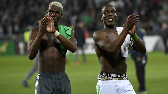 Gelandang Manchester United Paul Pogba (kiri) dan bek Saint-Etienne Florentin Pogba menyapa para penonton usai pertandingan Liga Europa antara Manchester United melawan Saint-Etienne, di Stade Geoffroy-Guichard, Rabu (22/2). (PHILIPPE DESMAZES/AFP)