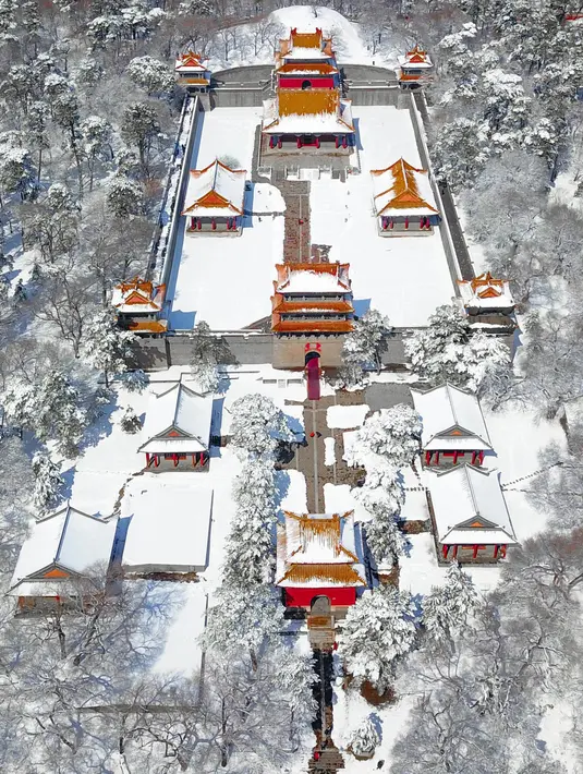 Pemandangan Taman Beiling saat diselimuti salju di Shenyang di provinsi Liaoning, China (15/3). Salju tebal tersebut membuat pemandangan di taman itu indah, karena perpaduan atap yang berwarna emas dengan putih salju. (AFP)