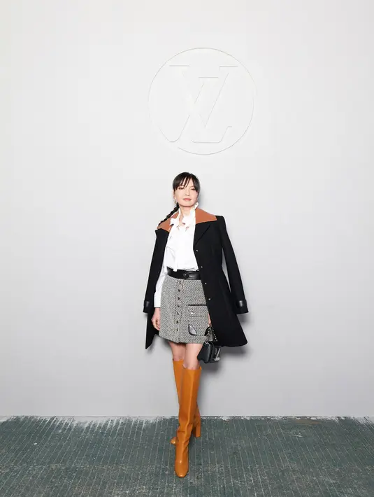Penampilannya dilengkapi dengan sepatu boots warna coklat dan sling bag hitam. Sementara rambutnya ditata ponytail with bangs.  [Foto: Louis Vuitton].