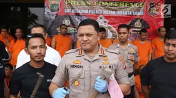 Kapolres Metro Jakarta Barat Kombes Pol Hengki Haryadi menunjukkan barang bukti beserta sejumlagh tersangka kasus premanisme di Mapolres Metro Jakarta Barat, Senin (12/11). (Liputan6.com/Immanuel Antonius)