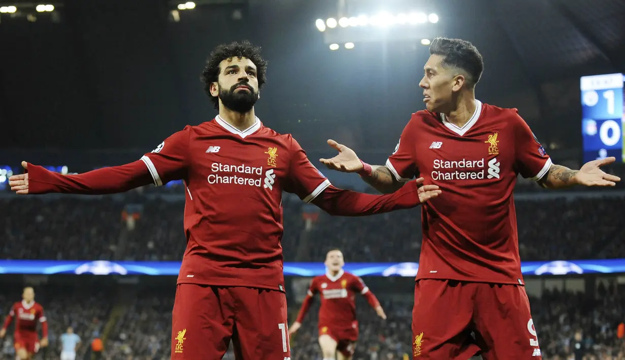 Striker Liverpool, Mohamed Salah dan Roberto Firmino, melakukan selebrasi usai mencetak gol ke gawang Manchester City pada laga Liga Champions di Stadion Etihad, Rabu (11/4/2018). Manchester City takluk 1-2 dari Liverpool. (AP/Rui Vieira)
