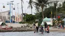 Pengunjung bersama anak-anak menikmati suasana Pantai Indah Taman Impian Jaya Ancol, Jakarta, Kamis (29/10/2020). Libur panjang di masa pemberlakuan PSBB transisi Jakarta dimanfaatkan warga untuk mengunjungi lokasi-lokasi wiisata. (Liputan6.com/Helmi Fithriansyah)