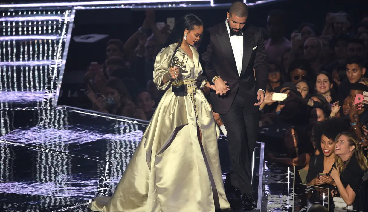 Drake menggandeng Rihanna saat turun dari atas panggung usai menerima penghargaan Michael Jackson Video Vanguard Award di ajang MTV VMA 2016, New York, AS, (28/8). (AFP PHOTO/ Jason Kempin)