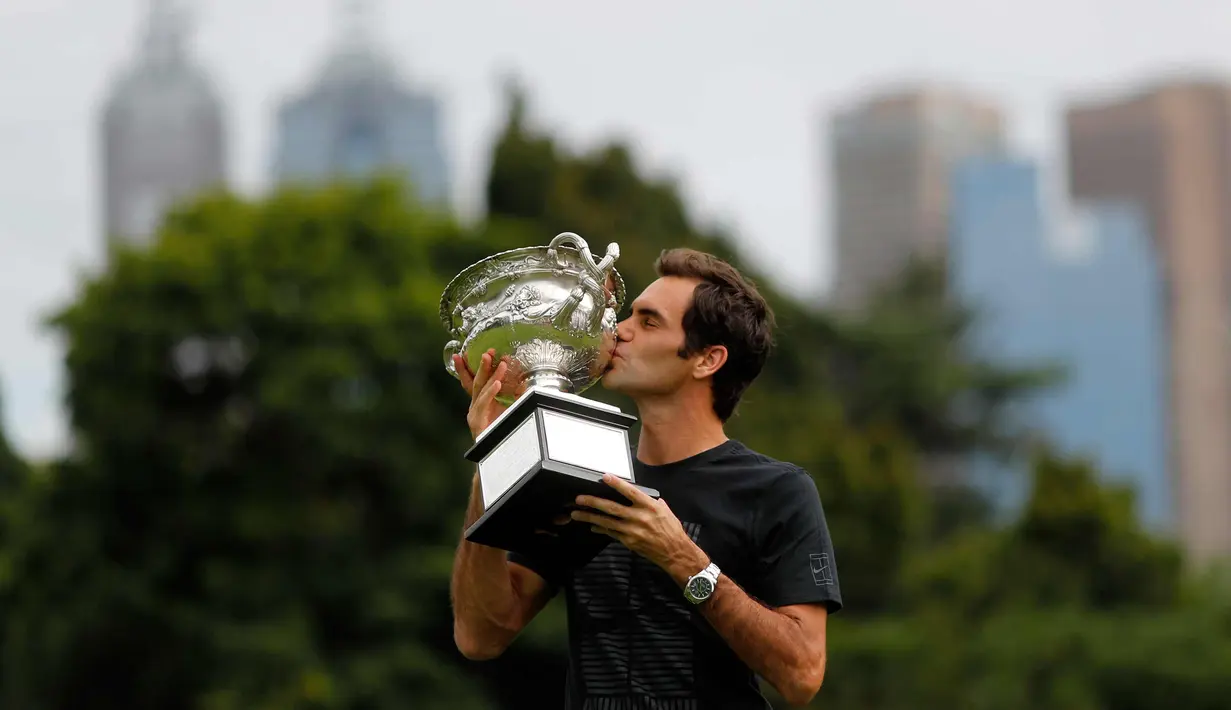 Petenis Swiss, Roger Federer mencium piala Challenge Norman Brookes di Government House, Melbourne, Australia (29/1). Federer mengalahkan petenis Kroasia Marin Cilic 6-2, 6-7(5), 6-3, 3-6, 6-1. (AP Photo/Ng Han Guan)