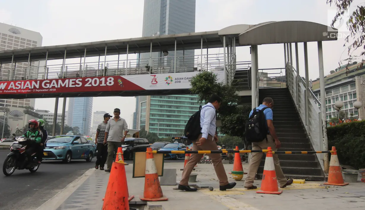 Pejalan kaki saat akan menggunakan jembatan penyeberangan orang (JPO) di Bundaran HI, Jakarta, Selasa (24/7). Pemprov DKI berencana merobohkan JPO tersebut karena menghalangi pandangan ke Patung Selamat Datang. (Liputan6.com/Arya Manggala)