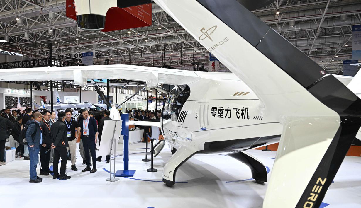Pengunjung terlihat di samping pesawat Zerog eVTOL model ZG-T6 di stan Zerog selama Aero Asia 2025 di Zhuhai, Provinsi Guangdong, Tiongkok selatan, pada Kamis 27 November 2025. Pameran penerbangan dan kedirgantaraan internasional Aero Asia 2025 resmi dibuka. (Hector RETAMAL/AFP)