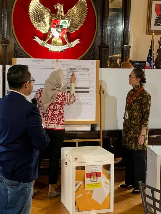 Petugas KPPS Luar Negeri mencatat perolehan suara saat penghitungan suara Pemilu 2019 yang dikirimkan melalui pos maupun yang dicoblos langsung di TPS oleh pemilih WNI, di KBRI Washington DC, Kamis (18/4). Jokowi meraih 1113, sementara pasangan Prabowo-Sandi meraih 352 suara. (Liputan6.com/HO/Butet)
